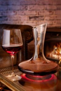 decantador de vino y copa de vino con reflejo rojo 